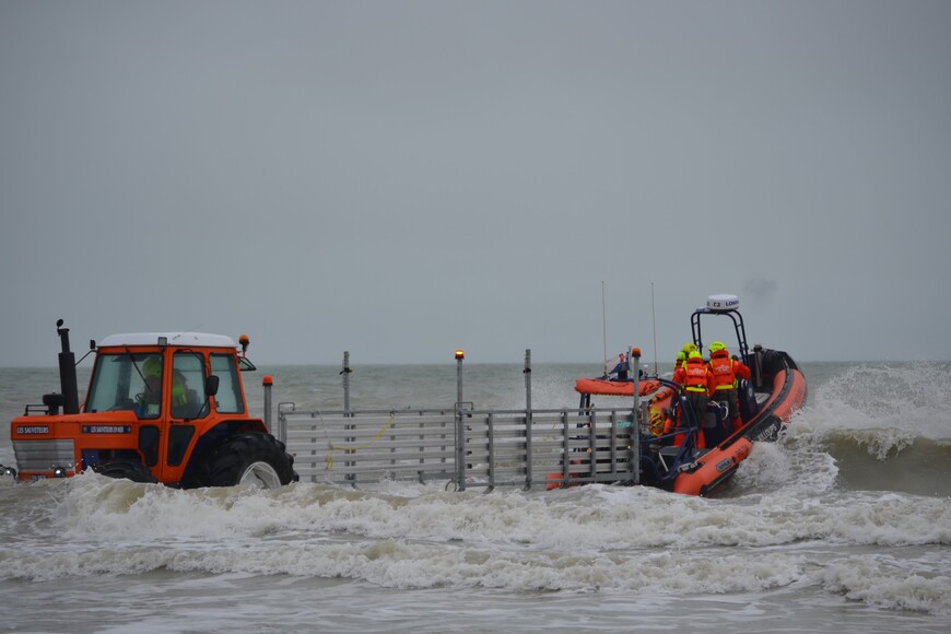 Les bénévoles de Jullouville utilisent un tracteur et une remorque pour mettre leur semi-rigide à l'eau