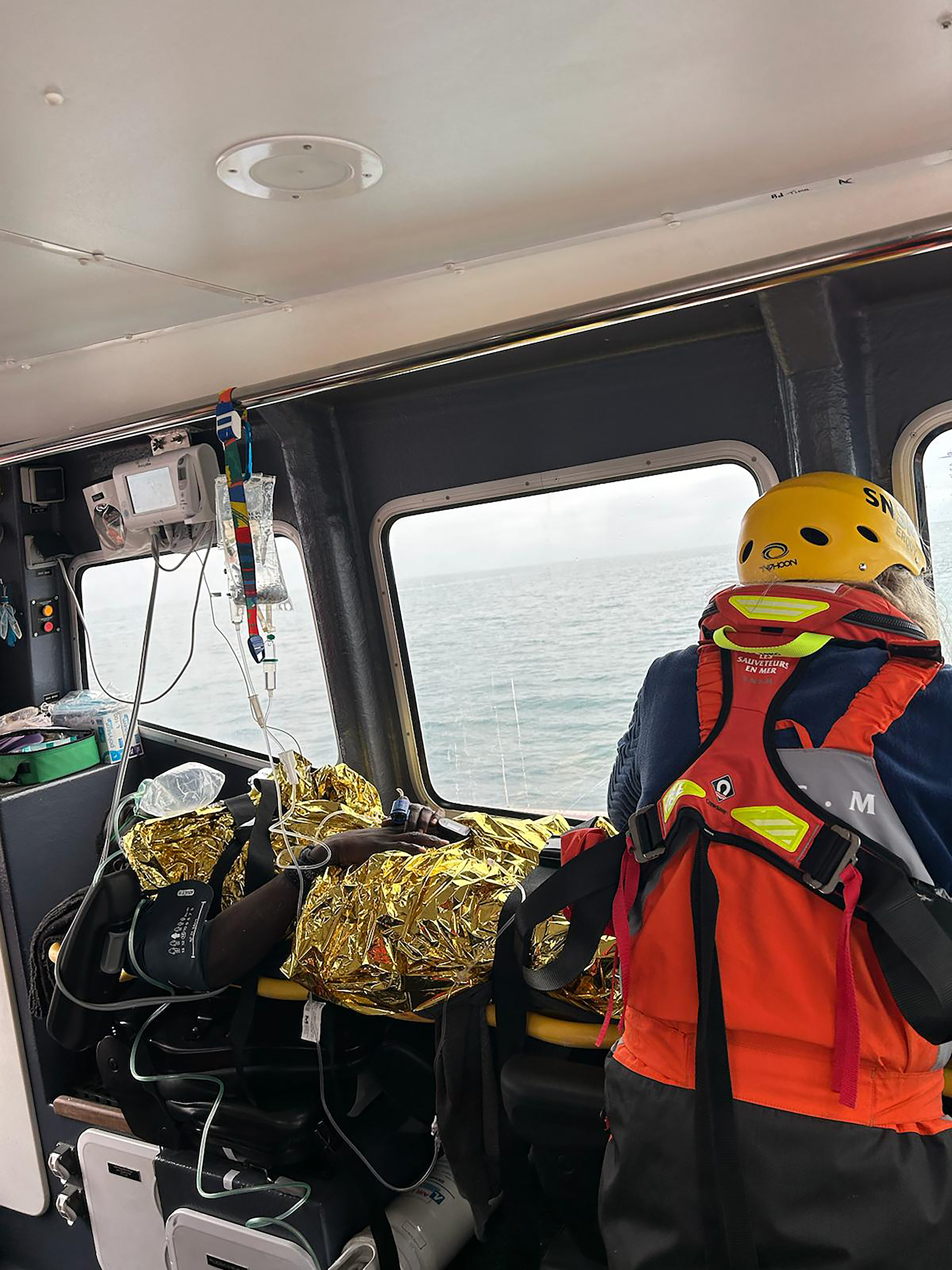 Un blessé allongé dans la cabine d'un bateau de sauvetage en mer